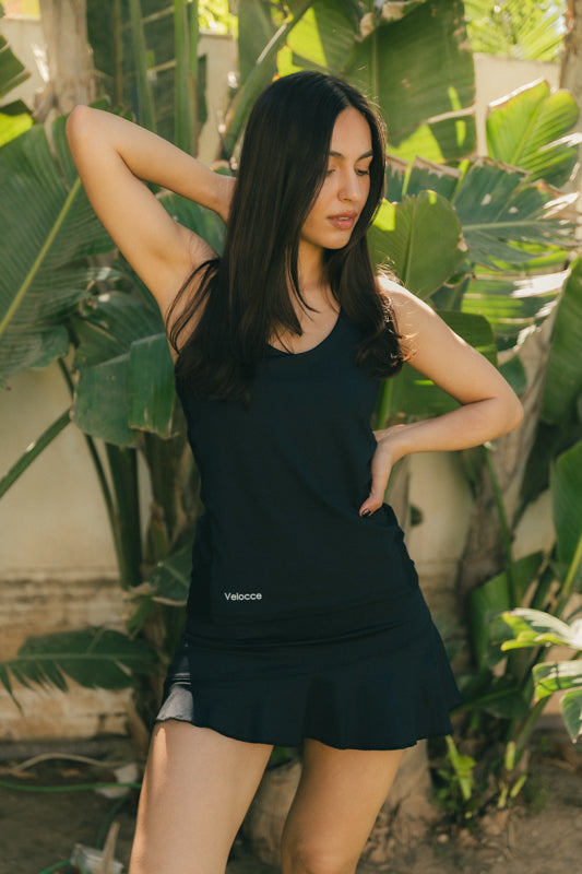 Mujer estirando con camiseta de padel negra - Plano general