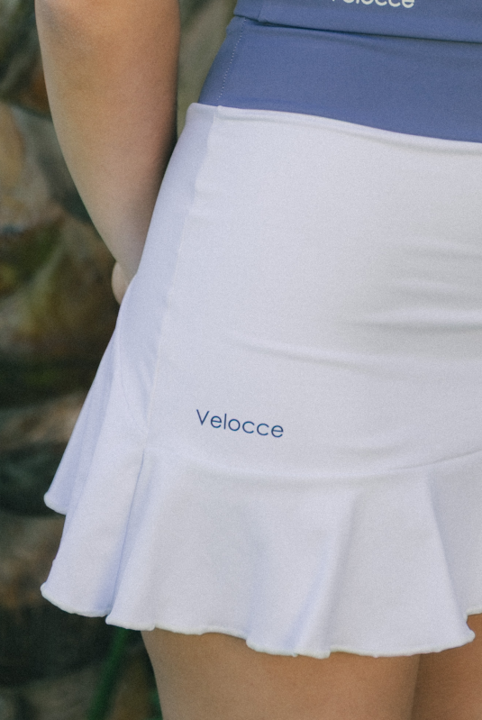 Mujer con conjunto de padel color blanco y azul - Primera plano falda