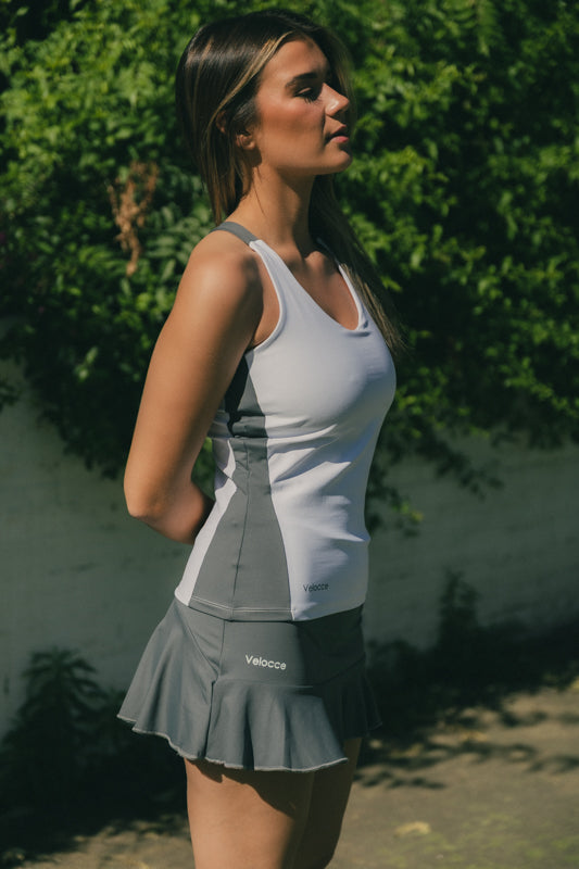 Mujer con conjunto de padel color blanco y gris - Plano lateral