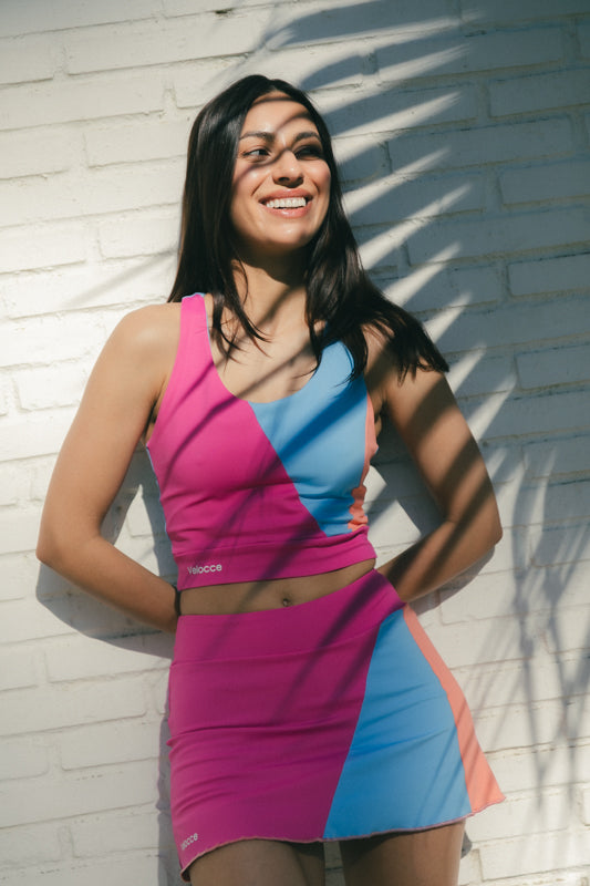 Mujer con conjunto de padel rosa, azul y naranja, multicolor - Plano general