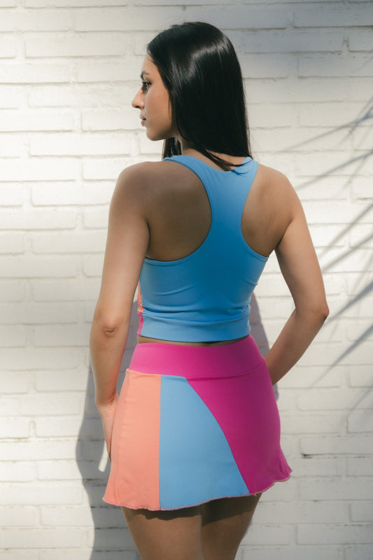 Mujer con conjunto de padel rosa, azul y naranja, multicolor - Plano trasero