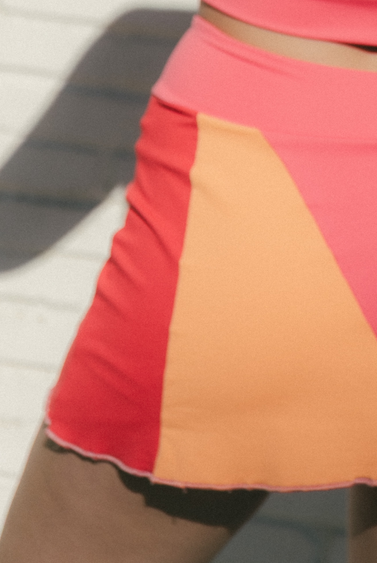 Mujer con conjunto de padel rosa y rojo - detalles