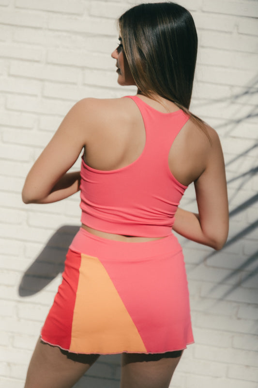 Mujer con conjunto de padel rosa y rojo - Plano medio trasero