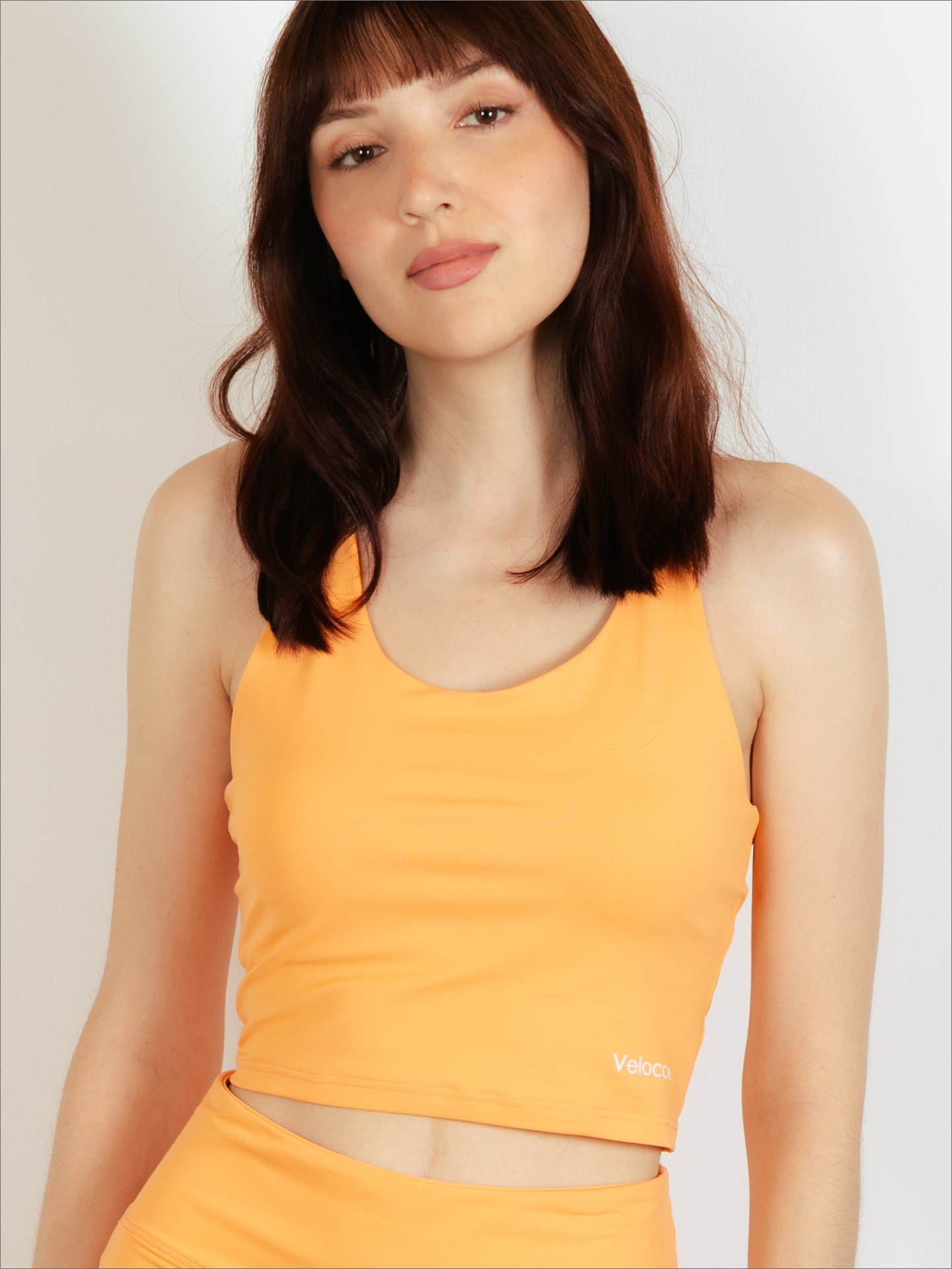 Mujer con top de padel color naranja