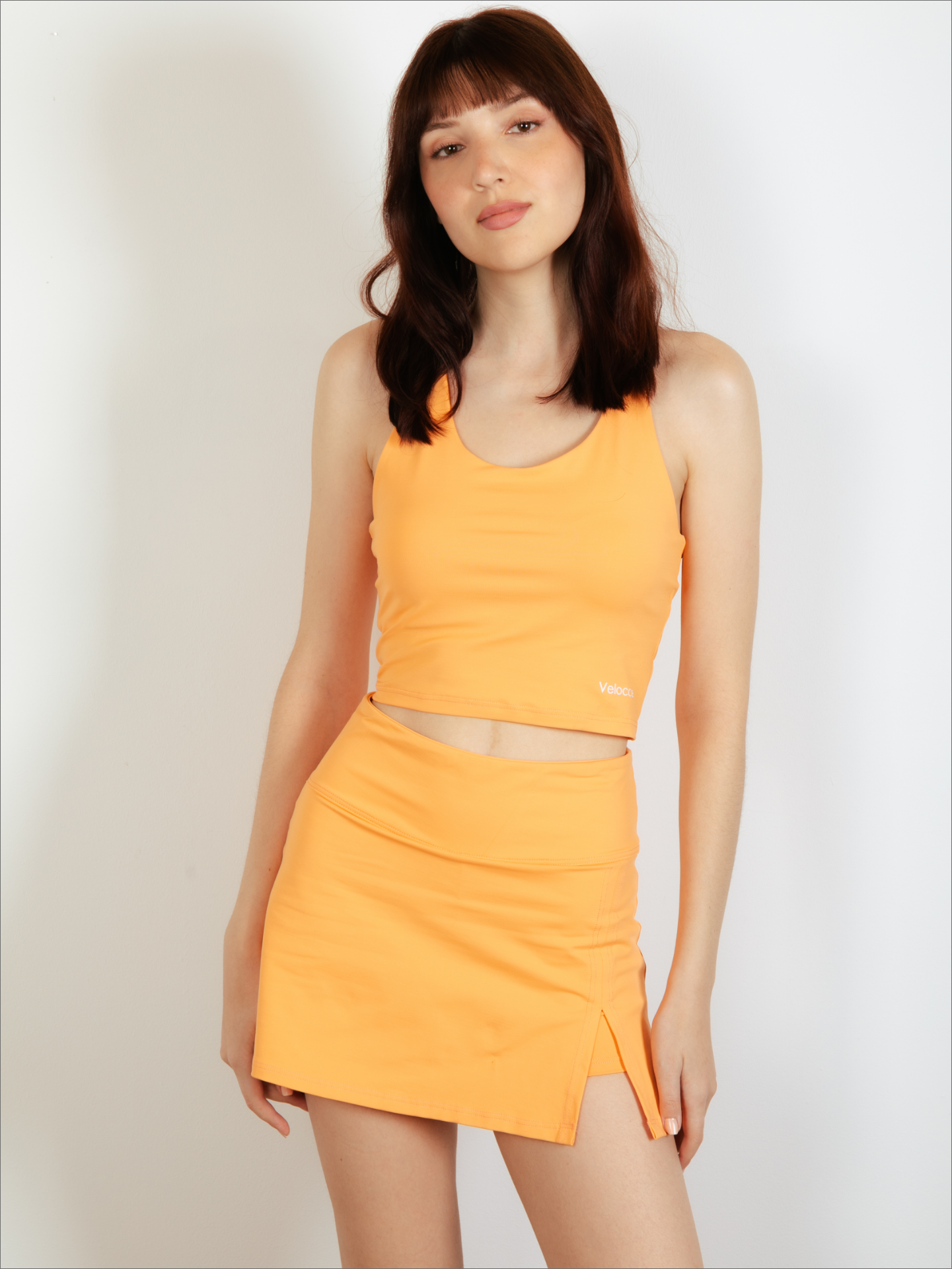 Mujer con top de padel color naranja - Plano general