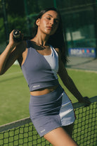 Mujer con conjunto de padel azul y rojo - Plano lateral