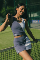 Mujer en pista de padel con conjunto de padel azul y rojo - Plano medio