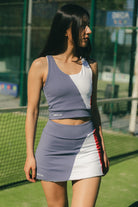 Mujer caminando con conjunto de padel azul y rojo - Plano medio