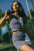 Mujer jugando con conjunto de padel azul y rojo - Plano detalle