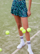 Mujer con falda de padel estampada en una pista de padel - Plano medio