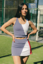 Mujer con conjunto de padel azul y rojo - Plano general